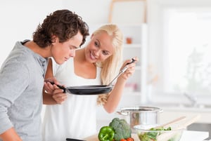 Couple cooking with a pan in their kitchen