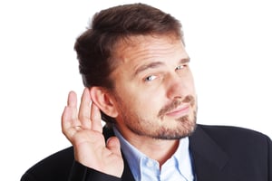 Mature Business man holding his hand to his ear trying to hear you, isolated on white
