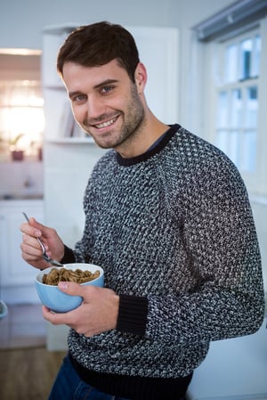 Portrait of man having cereal for breakfast in kitchen at home