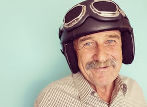 Senior funny man as a pilot with hat and glasses