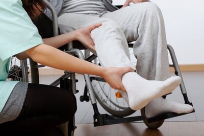 Young physiotherapist exercising with elder disabled person-1